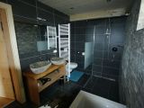 modernes Badezimmer mit Steinwand und Holz-Wasch-Tisch